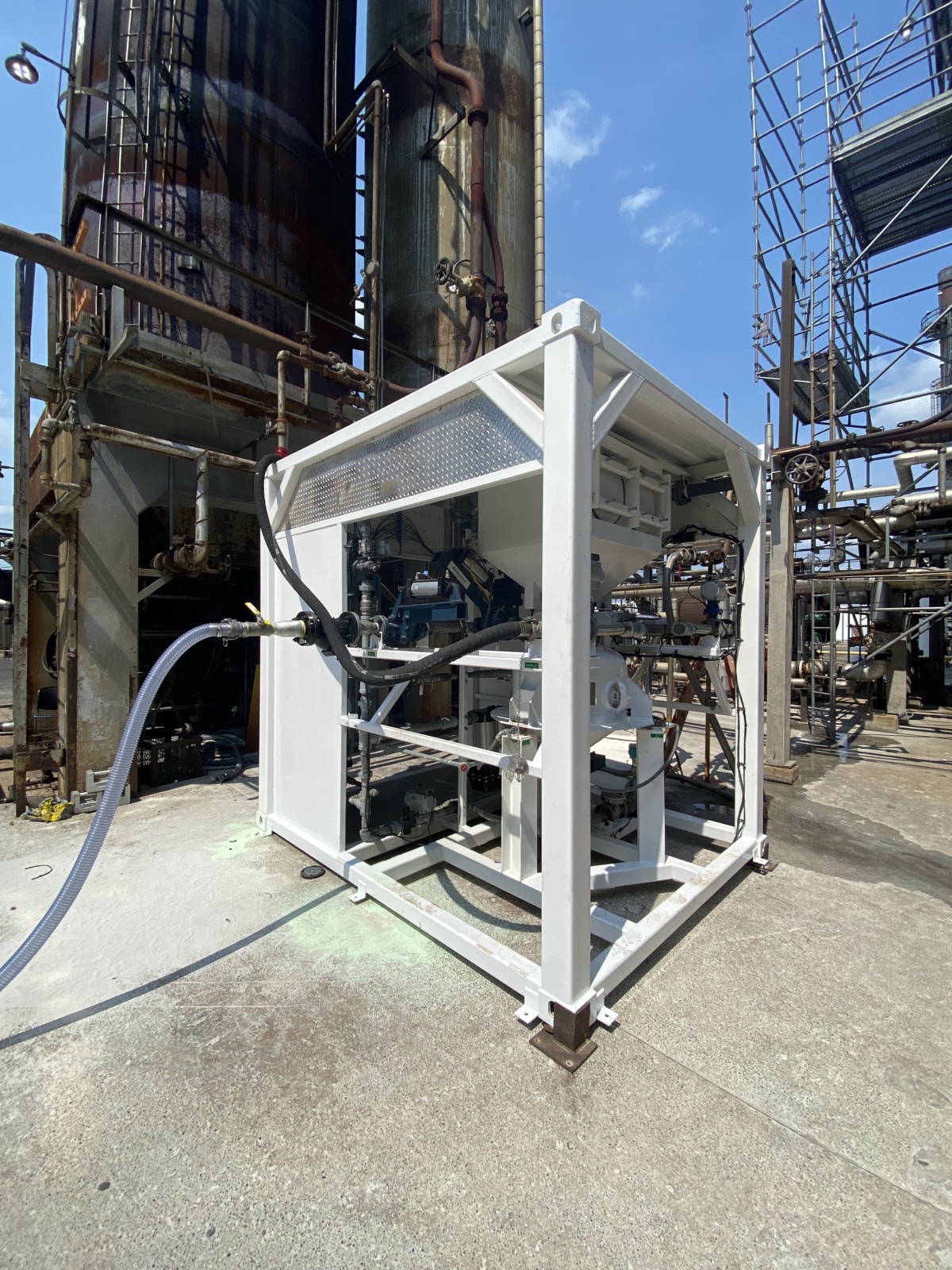 Skid-mounted unit beside refinery process columns